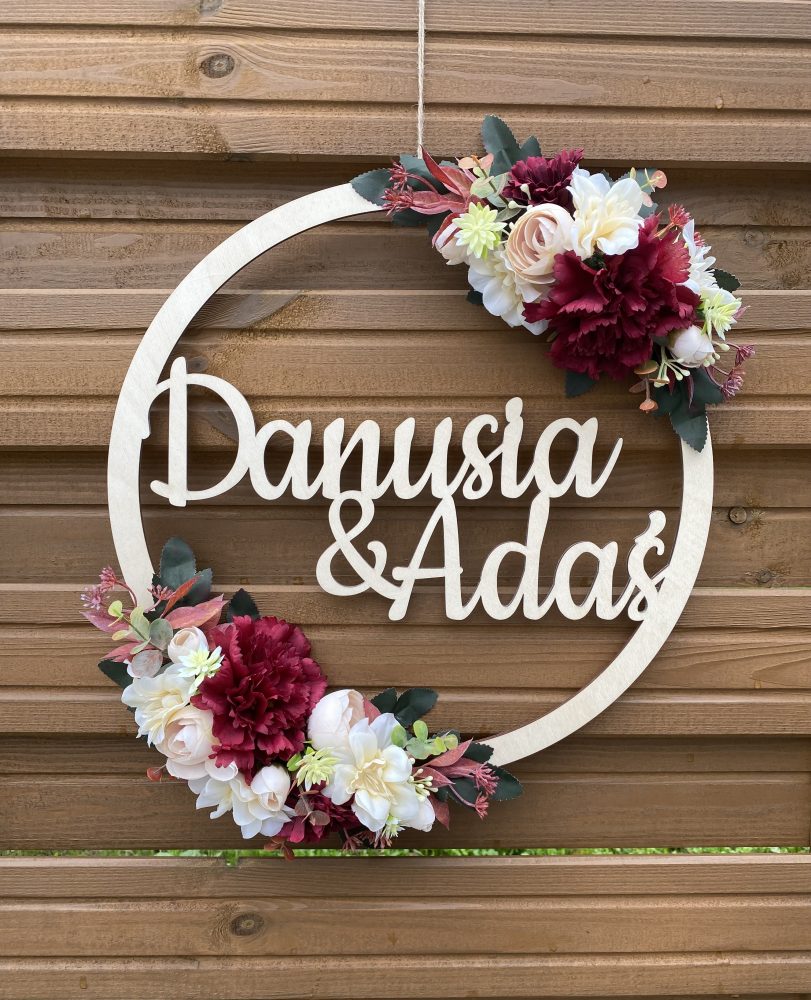 Drewniana obręcz z imionami ozdobiona kwiatami na Ślub i Wesele